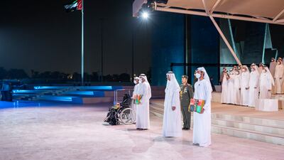 Sheikh Hamad bin Mohammed Al Sharqi, Ruler of Fujairah, stands with families of heroes during a Commemoration Day ceremony at Wahat Al Karama. Photo: Mohamed Al Hammadi / Ministry of Presidential Affairs