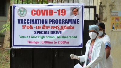 A doctor passes a banner in Hyderabad announcing a special vaccination programme against Covid-19. AFP