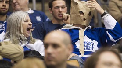 A women yawns, left, as a Toronto Maple Leafs fan wears a paper bag on his head as the Maple Leafs play against the Tampa Bay Lightning in 2012. Nathan Denette / AP file