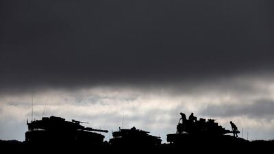 A file photo of Israeli soldiers working on their tanks during a military exercise in the Israeli controlled Golan Heights, near the border with Syria. Ariel Schalit/AP Photo