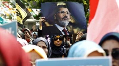 A woman holds a picture of Mohamed Morsi during a protest against an Egyptian court's decision to seek the death sentence for deposed former Egyptian President in Istanbul, Turkey. Ulas Yunus Tosun / EPA