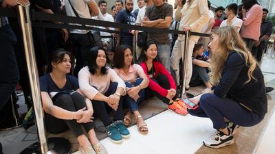 Apple customers queue through the night at The Dubai Mall to be one of the first to get the new Apple devices. Leslie Pableo / The National