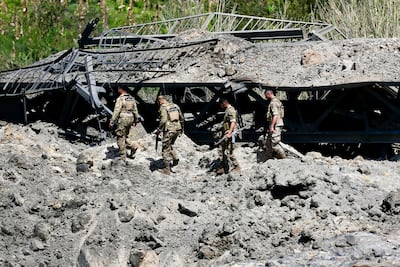 Lebanese army soldiers cross a damaged part of the Qasmiyeh Bridge, which was hit by an Israeli air strike. EPA