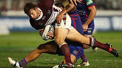 Josh Perry of Manly takes on the Newcastle defence during their NRL match at Bluetongue Stadium yesterday.