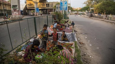Homeless Indian children sit in the middle of a deserted road, amid a nationwide lockdown, in New Delhi. Getty Images