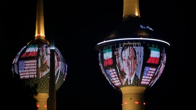Kuwait's Towers in Kuwait City are illuminated in the colours of the American flag and a portrait of former US president George H.W. Bush on December 1, 2018, in tribute to the former US president. AFP / Yasser Al-Zayyat