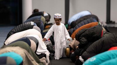 Zaiyan, aged two, walks among men praying at the One City Park event in Bradford. AFP