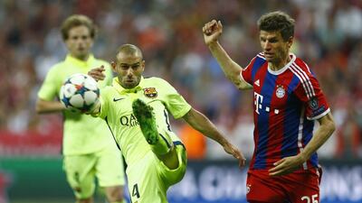 Barcelona’s Javier Mascherano kicks at the ball near Bayern Munich’s Thomas Muller during their Champions League match on Tuesday. Matthias Schrader / AP