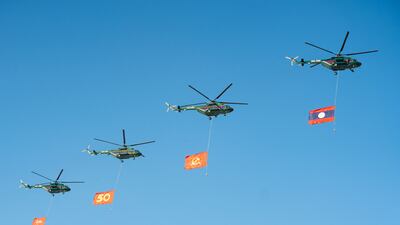 Air force helicopters carry flags during the Laos national day military parade in the capital, Vientiane. AFP