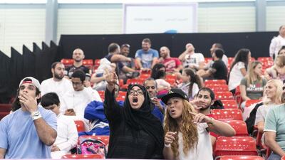Friends cheer on Salwa Al Ali, in blue, from Al Jazira Jiu-Jitsu club at Al Ain Jiu Jitsu Open Championship. Reem Mohammed / The National