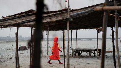 An Indian sadhu (holy man) walks past burning garbage at Sangam, the confluence of the Ganges, Yamuna and mythical Saraswati rivers in Allahabad. Sanjay Kanojia / AFP