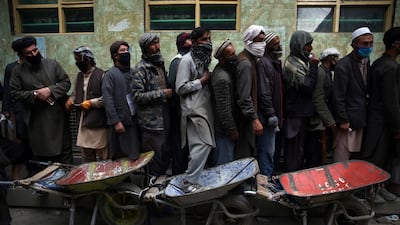 Afghan labourers queue to receive free wheat in Kabul. AP Photo