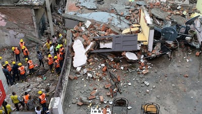 Indian rescue workers and other officials clear the rubble of a collapsed building in New Delhi on July 19. AFP Photo