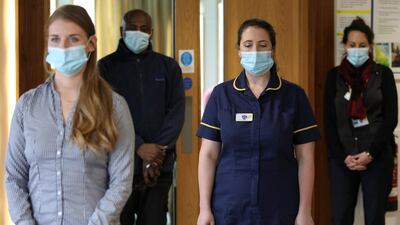Healthcare workers and staff members observe a minute of silence at the Marie Curie Hospice in Hampstead, in London. Reuters