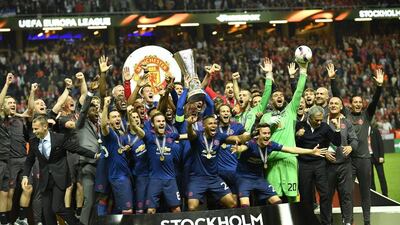 Manchester United players and staff celebrate with the Europa League trophy. Peter Powell / EPA