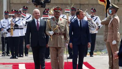 Iraqi President Barham Salih and French President Emmanuel Macron, right, review the guard of honour as they arrive at the Salam Palace in Baghdad. AP