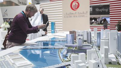 A visitor takes a photo of the masterplan for Al Maryah Island. Mona Al Marzooqi / The National