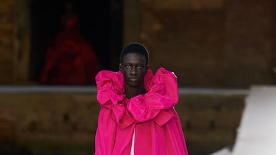 At Valentino autumn 2021 haute couture, even men's wear arrives with a raspberry cape, gathered at the neck