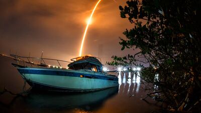 A long-exposure shows a streak across the sky above an abandoned boat during the launch of a Falcon 9 rocket and 60 Starlink satellites. The launch was from Cape Canaveral Space Force Station. Florida Today via AP