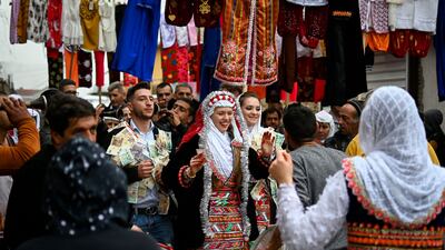 Guests in colourful costumes dance during the wedding. AFP