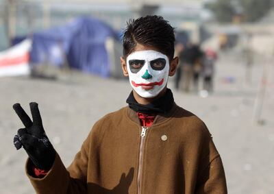 An Iraqi protester wearing face-paint imitating The Joker poses for a picture near the sit-in by Senak bridge over the Tigris in the capital Baghdad on December 25, 2019. AFP