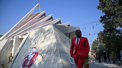 A man walks past a Santa Claus image on the side of Fatima Church after Christmas Day prayers in Islamabad, Pakistan. AFP