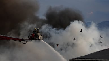 Firefighters battle a blaze at a plastics and packaging factory in Cali, Colombia. EPA
