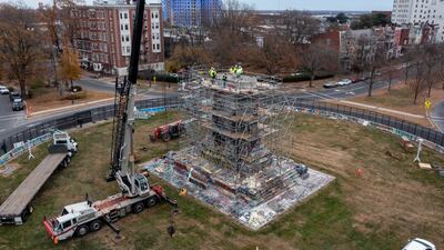 Workers disassemble the pedestal that once held the statue of Confederate Gen Robert E. Lee on Monument Avenue in Richmond, Virginia. AP