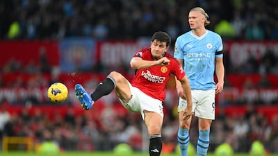 Harry Maguire of Manchester United attempts to pass the ball whilst under pressure from Erling Haaland. Getty