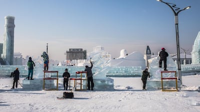Participants carve their ice sculptures. EPA