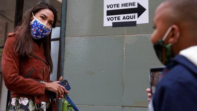 Congresswoman Alexandria Ocasio-Cortez greets a child as she waits in line to vote early at a polling station in The Bronx, New York City, US, October 25, 2020. REUTERS
