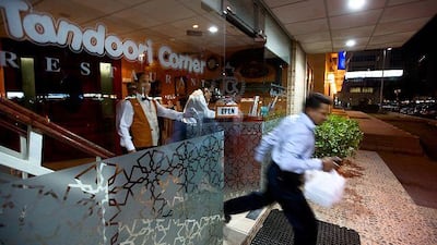 Basheer Alumgal dashes from Tandoori Corner restaurant to deliver a takeaway food order. He has lived in Abu Dhabi for 16 years and says it never takes more than 40 minutes to complete a delivery.