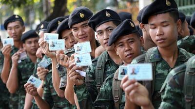 Thai soldiers pose with their identity cards as they wait to vote. The army deployed 5,000 soldiers in Bangkok to boost security for Sunday's general election. AP Photo