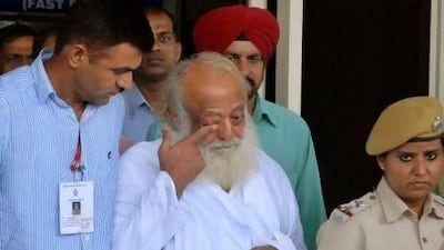 Controversial spiritual guru Asaram Bapu, in white, is brought for interrogation by police at the Jodhpur airport.