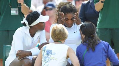 Serena Williams, centre, will return to the court on Wednesday for a WTA event for the first time since her disturbing exit from a Wimbledon doubles match with her sister Venus, left, due to a virus. Steve Reigate / AP Photo