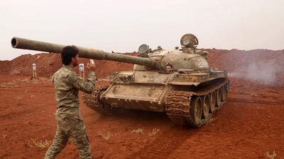 Syrian rebel-fighters from the National Liberation Front (NLF) secure a tank, part of heavy weapons and equipment withdrawn from a planned buffer zone around Idlib. AFP
