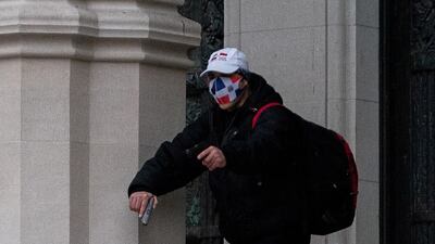 A man wearing a protective mask points his guns outside the Cathedral Church of St John the Divine in the Manhattan borough of New York City. Reuters