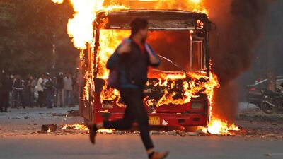 A man runs past a burning bus that was set on fire by demonstrators during a protest against a new citizenship law, in New Delhi, India, December 15, 2019. REUTERS/Adnan Abidi TPX IMAGES OF THE DAY