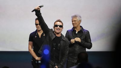 Bono, centre, of U2 gestures to the audience after performing at an Apple event at the Flint Center in Cupertino, California, September 9, 2014. Stephen Lam / Reuters
