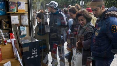 Tunisians stop to look in the window of Al Kitab Bookshop in Tunis. Lindsay Mackenzie / The National
