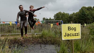 Patrick Colan-O'Leary, left, and Conor McCarthy, right, take a dip in the Bog Jacuzzi after competing in the Irish Bog Snorkelling championship on Sunday. Charles McQuillan / Getty Images