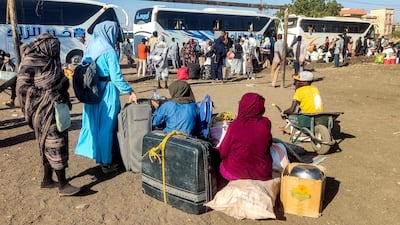 People displaced by the war in Sudan prepare to board buses to return to the city of Wad Medani in Al Gezira state, after it was retaken by the army. AFP