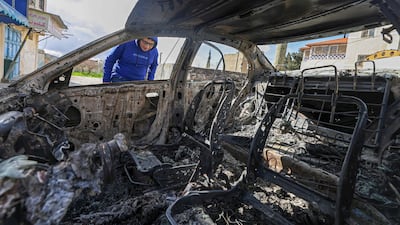 A Palestinian looks at a burnt vehicle following an attack by Israeli settlers in Jalud village, south of Nablus in the occupied West Bank, on March 22, 2026. AFP