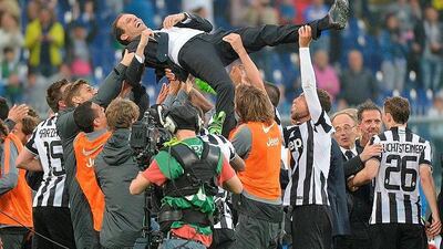Players and coaching staff lift Juventus manager Massimiliano Allegri after they were crowned Italian champions. Luca Zennaro / EPA