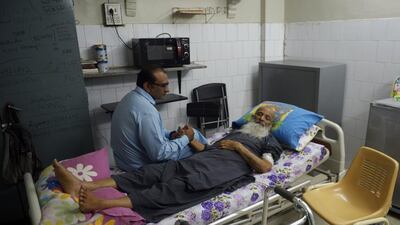 Abdul Sattar Edhi, head of Pakistan’s Edhi Foundation, with his son Faisal at the organisation’s centre in Karachi. After decades working around the clock on a punishing schedule, Mr Edhi’s health is now failing. Rizwan Tabassum / AFP