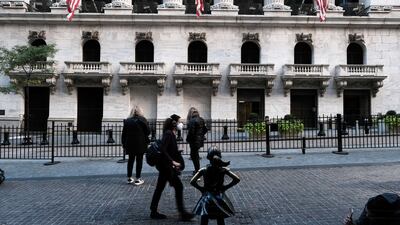 The 'Fearless Girl' sculpture is seen outside the New York Stock Exchange building. Wall Street stocks finished strong on Friday as investors pinned their hopes on lower interest rate rises from the US Federal Reserve. AFP