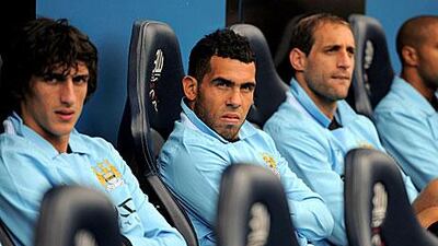 Carlos Tevez, the Manchester City forward, centre, has been fined four weeks' wages by the club.