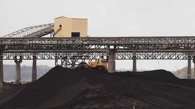A tractor makes its way over a pile of coal at a coal port in Gladstone, Queensland. Increasing energy costs influenced voters at the polls. Reuters