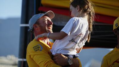 Abu Dhabi Ocean Racing crew member Justin Slattery, from Ireland, celebrates with his daughter after arriving in port to Cape Town to complete Leg 1 of the Volvo Ocean Race on Wednesday. Nic Bothma / EPA