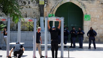 Men install metal detectors at an entrance to the compound known to Muslims as Noble Sanctuary and to Jews as Temple Mount, in Jerusalem's Old City July 16, 2017. Ammar Awad / Reuters